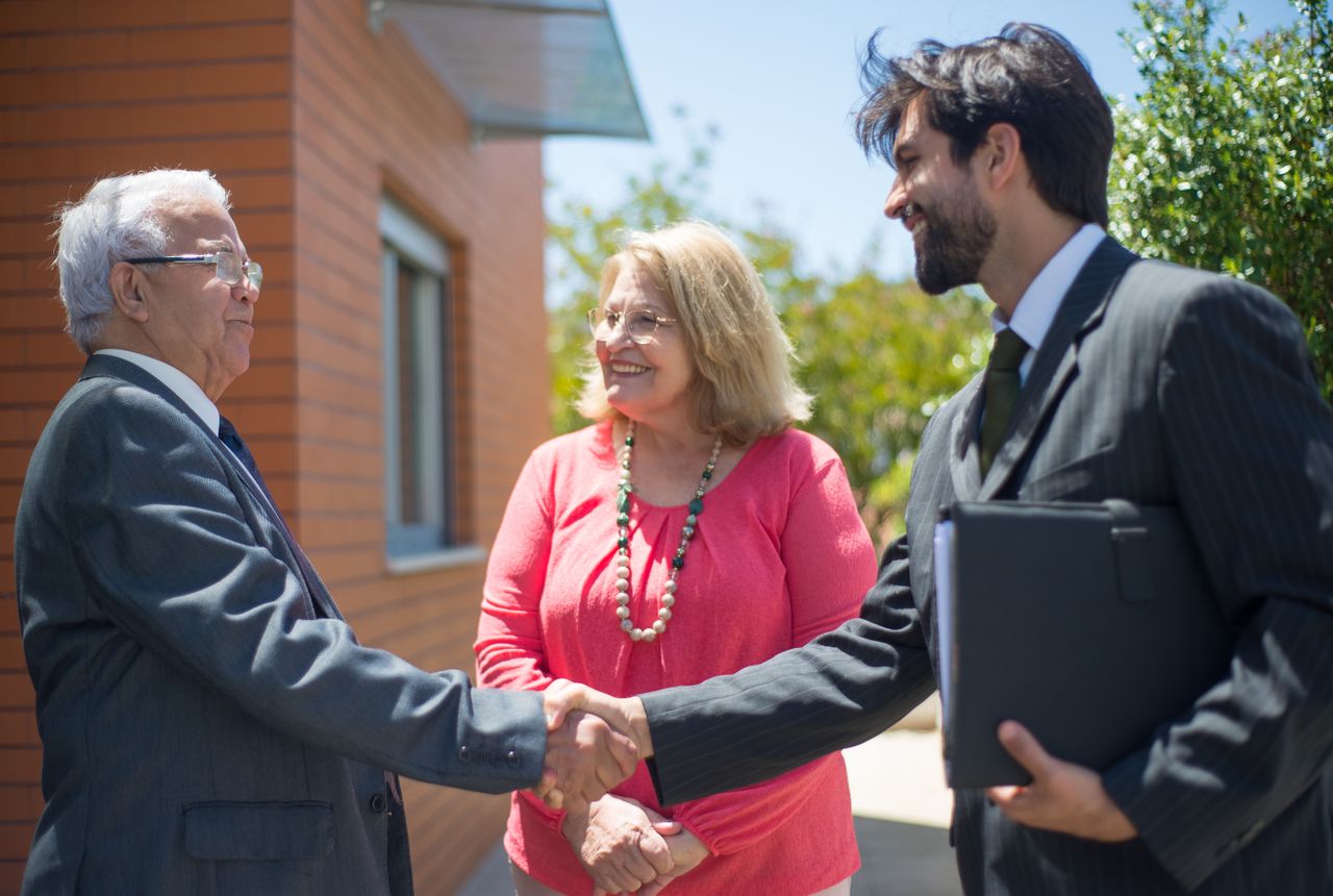 A professional shaking hands with happy homeowners — our money-back guarantee