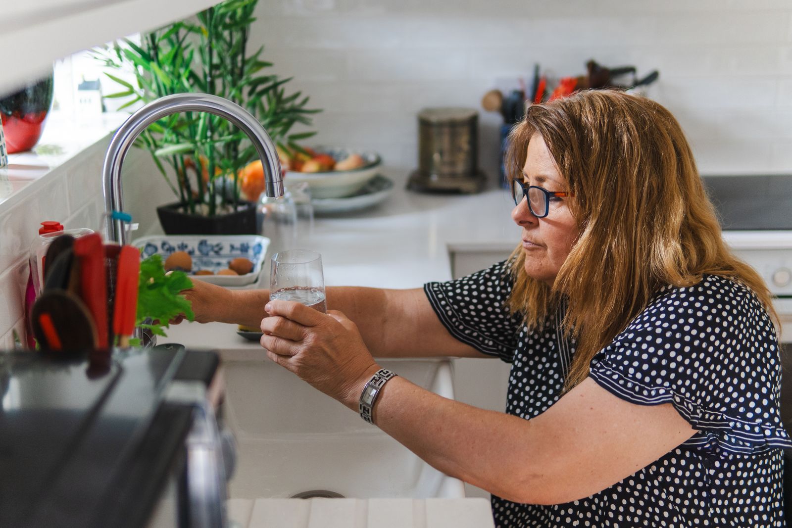 A hand filling a clear glass with Jacksonville tap water