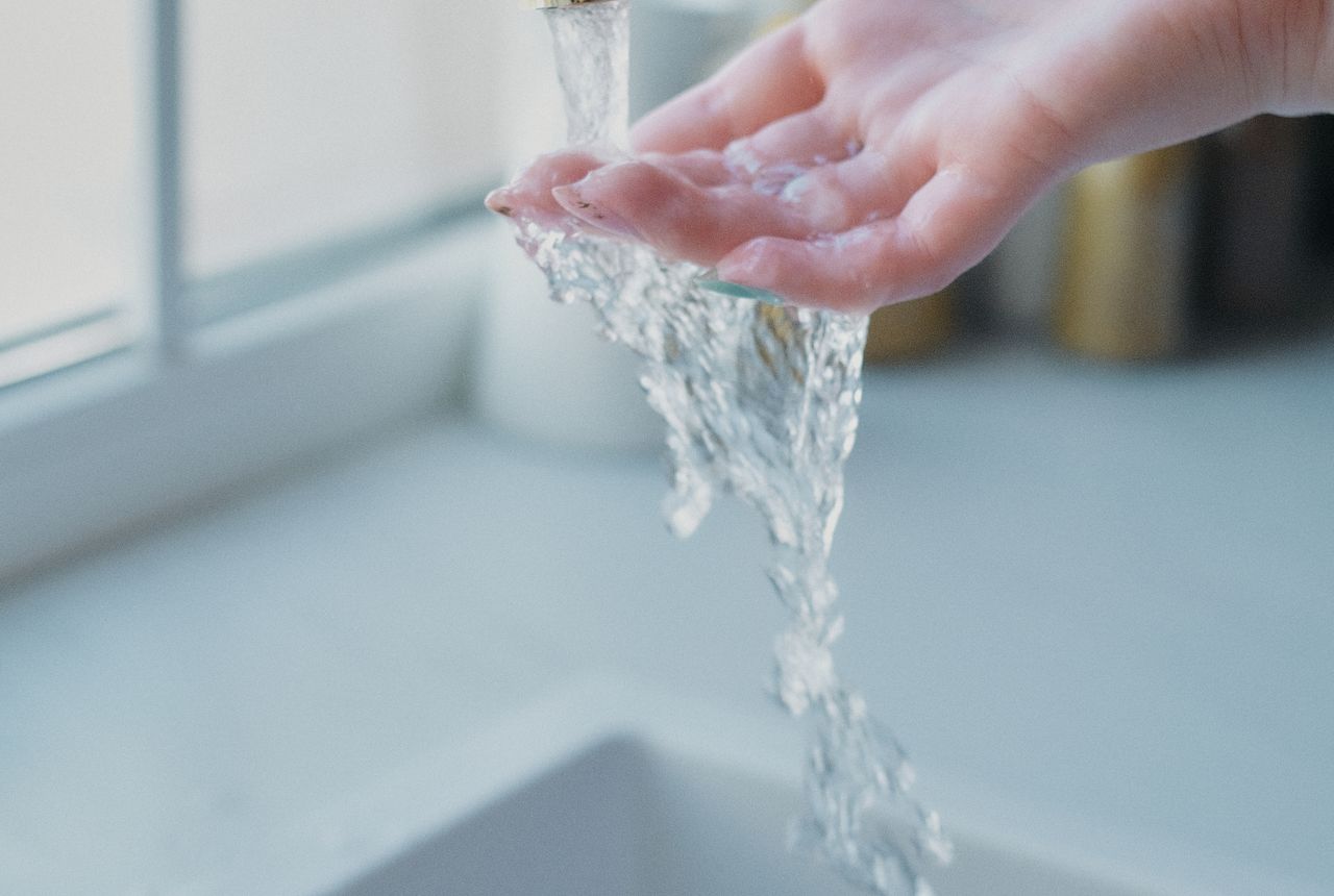 Soft, conditioned water running over a hand — softer skin and hair from whole-home softening