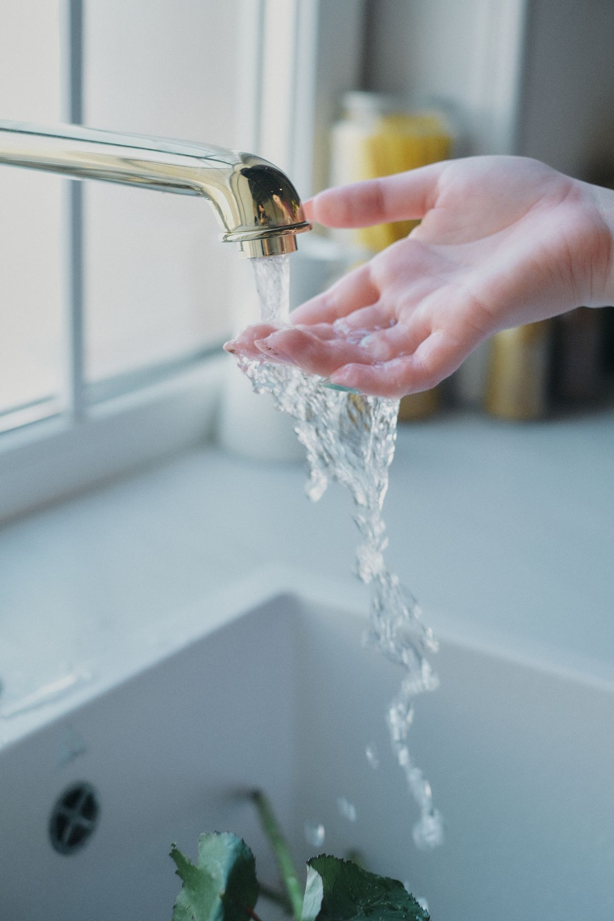 Soft, conditioned water running gently over a hand — gentler on skin and hair