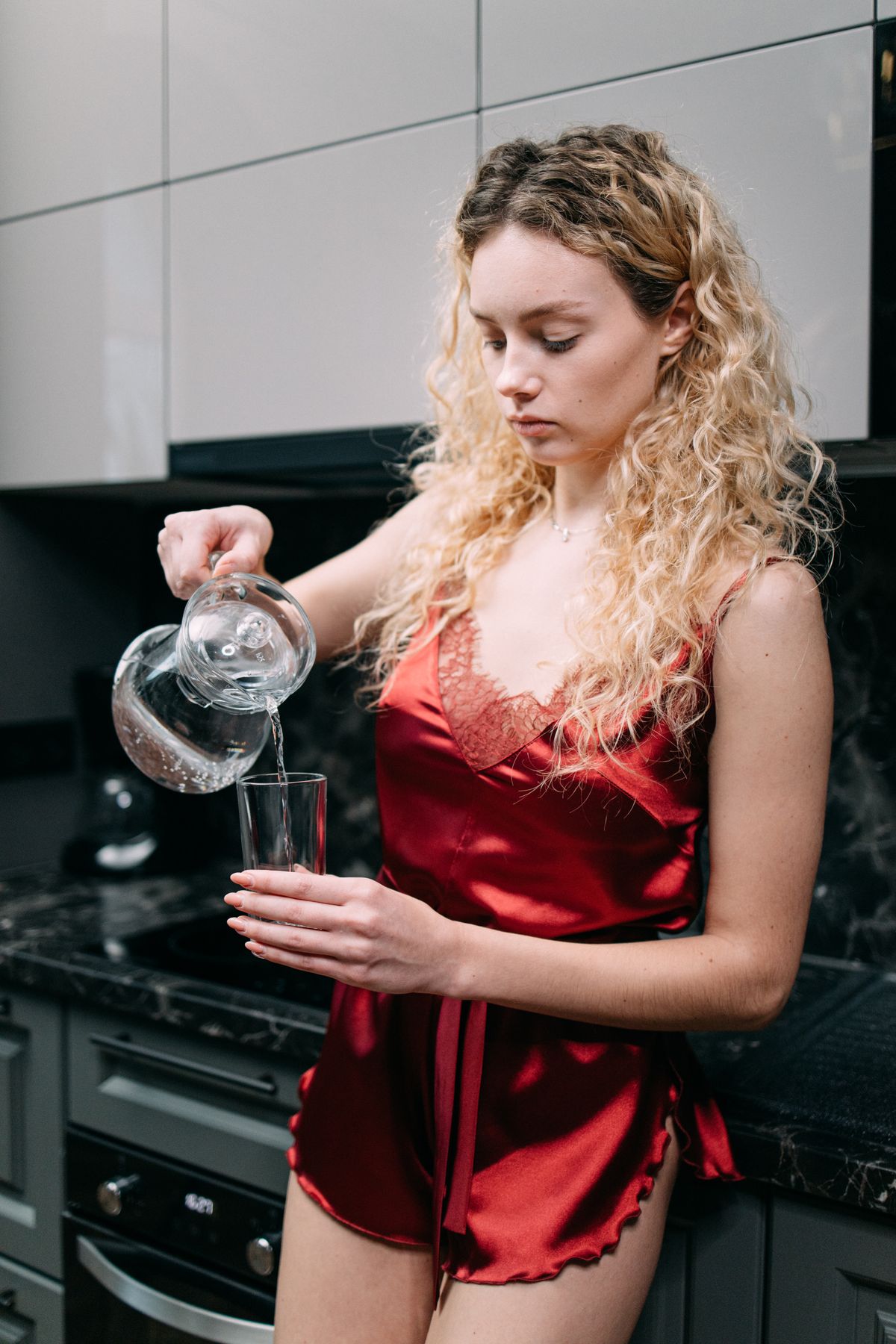 A woman pouring a glass of soft, clean water made possible by ion exchange softening